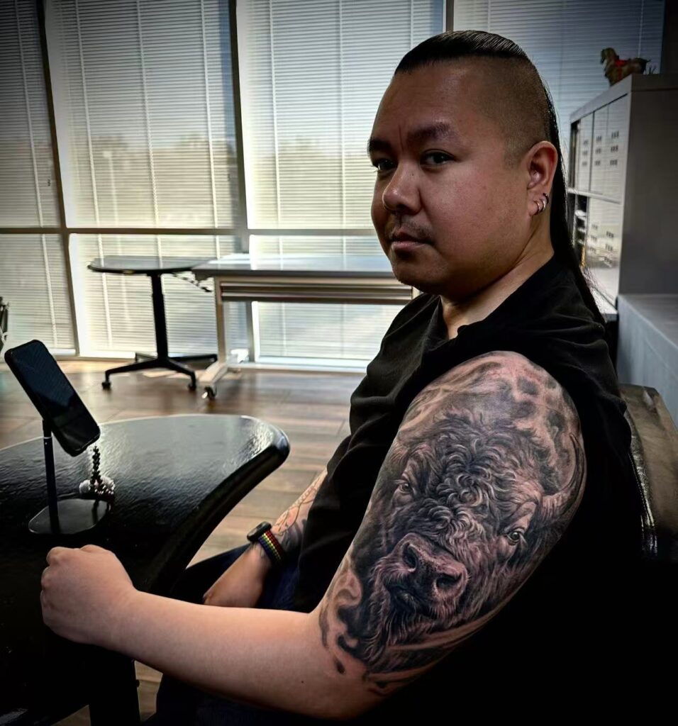 Dawei Tattoo artist portrait showing detailed arm sleeve tattoo